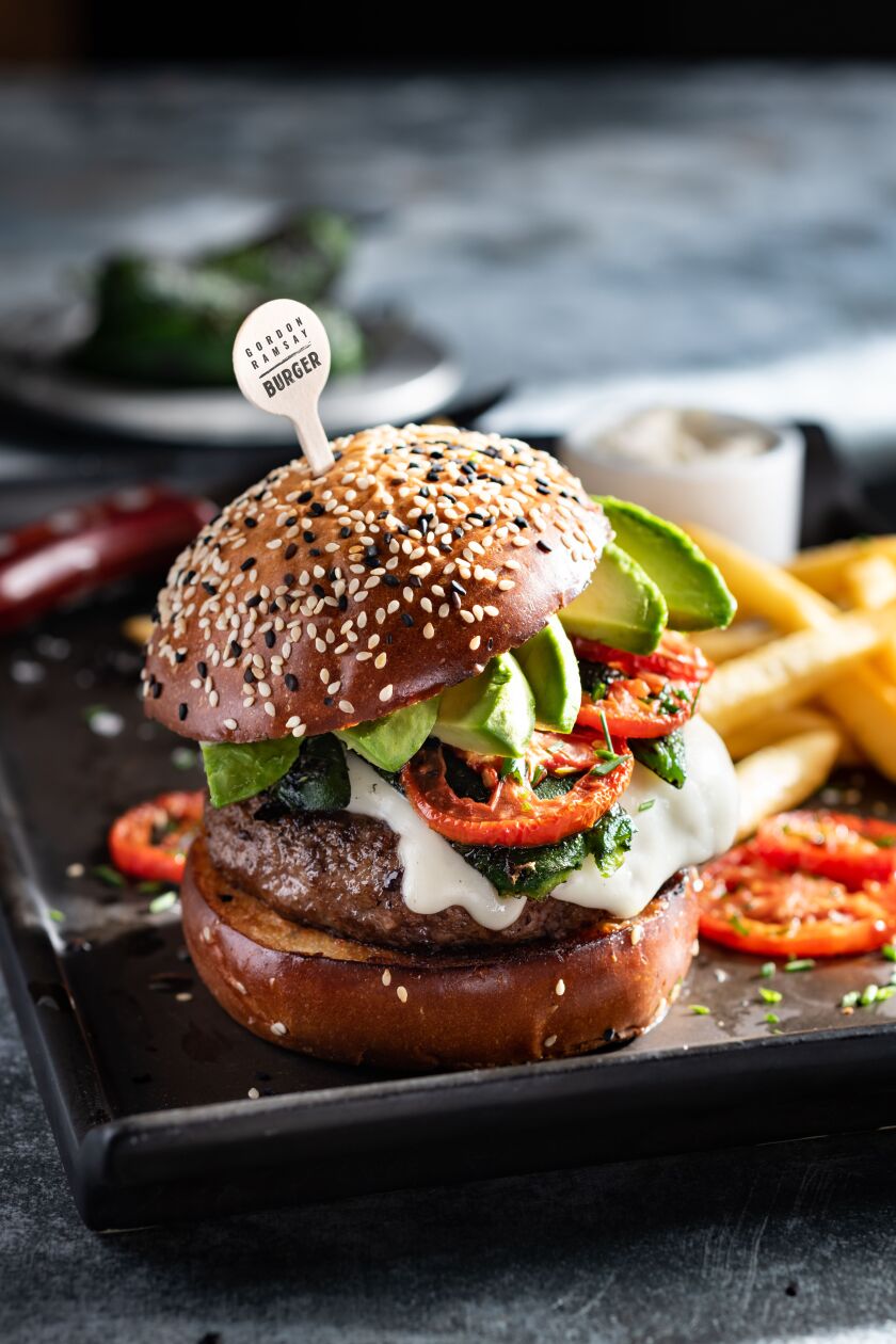 The Hell’s Kitchen Burger, topped with Asadero cheese, roasted jalapenos, avocado, roasted tomatoes and jalapeno aioli, is served at Gordon Ramsay Burger in Chicago.